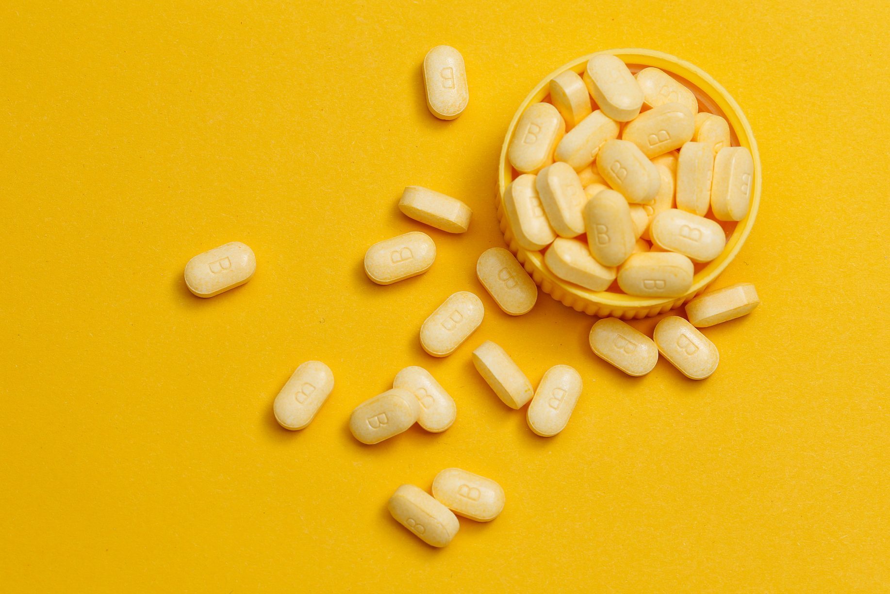 vitamin B tablets on yellow background