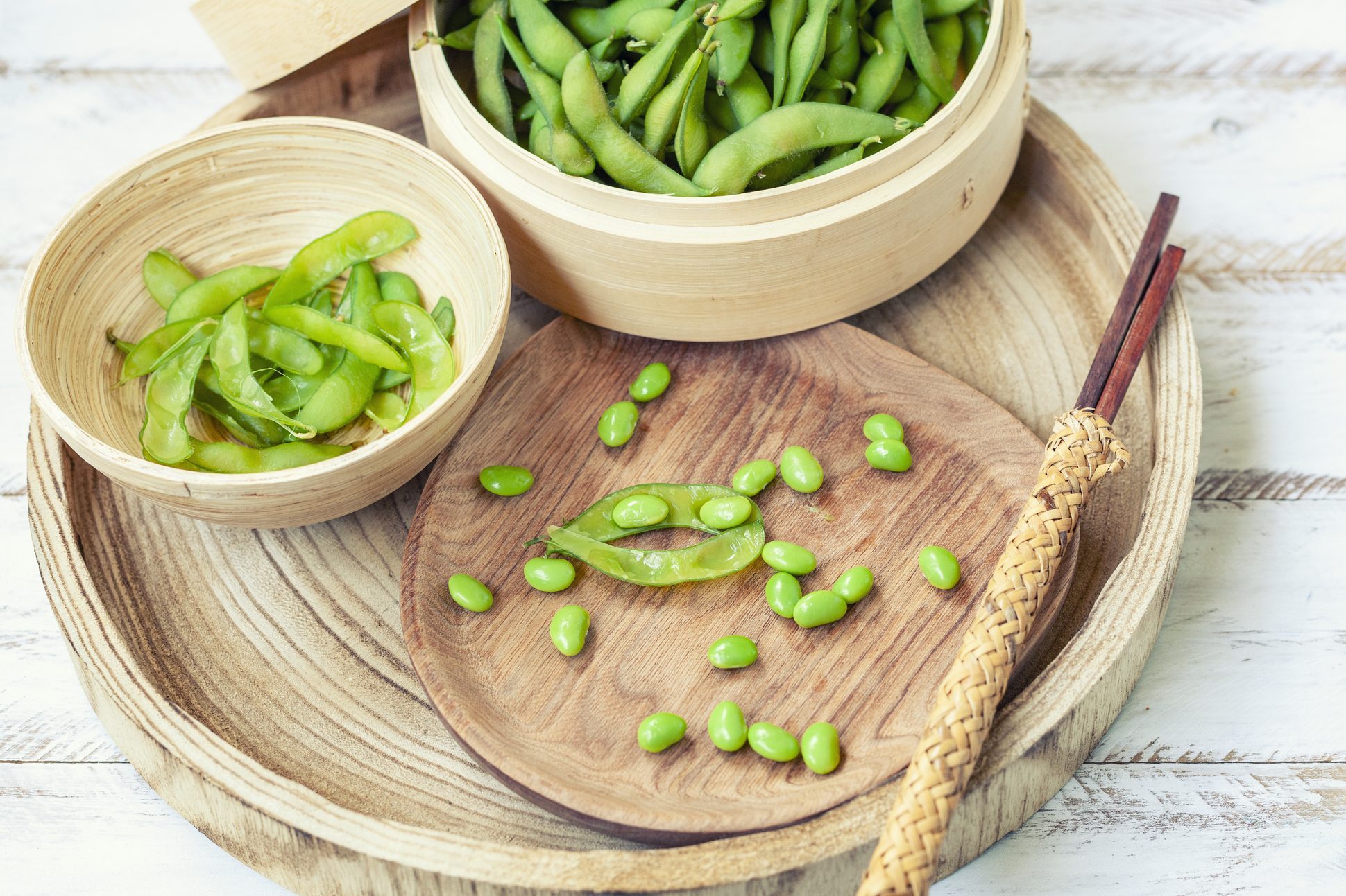 Bamboo steamer with boiled edamame and chopsticks