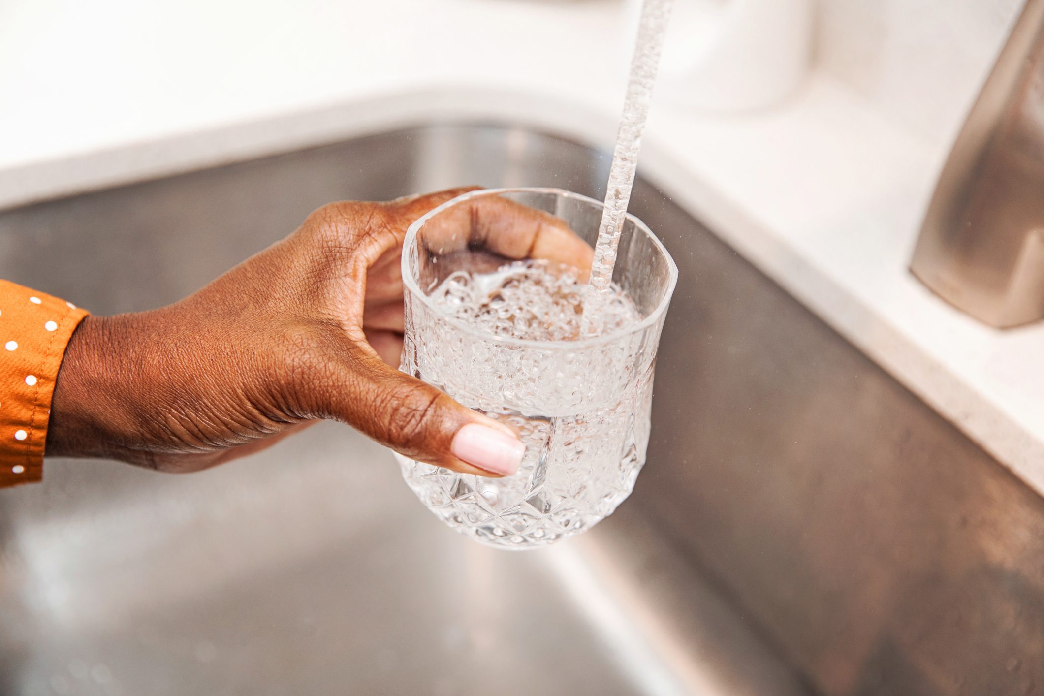 Pouring Some Tap Water Into Her Glass