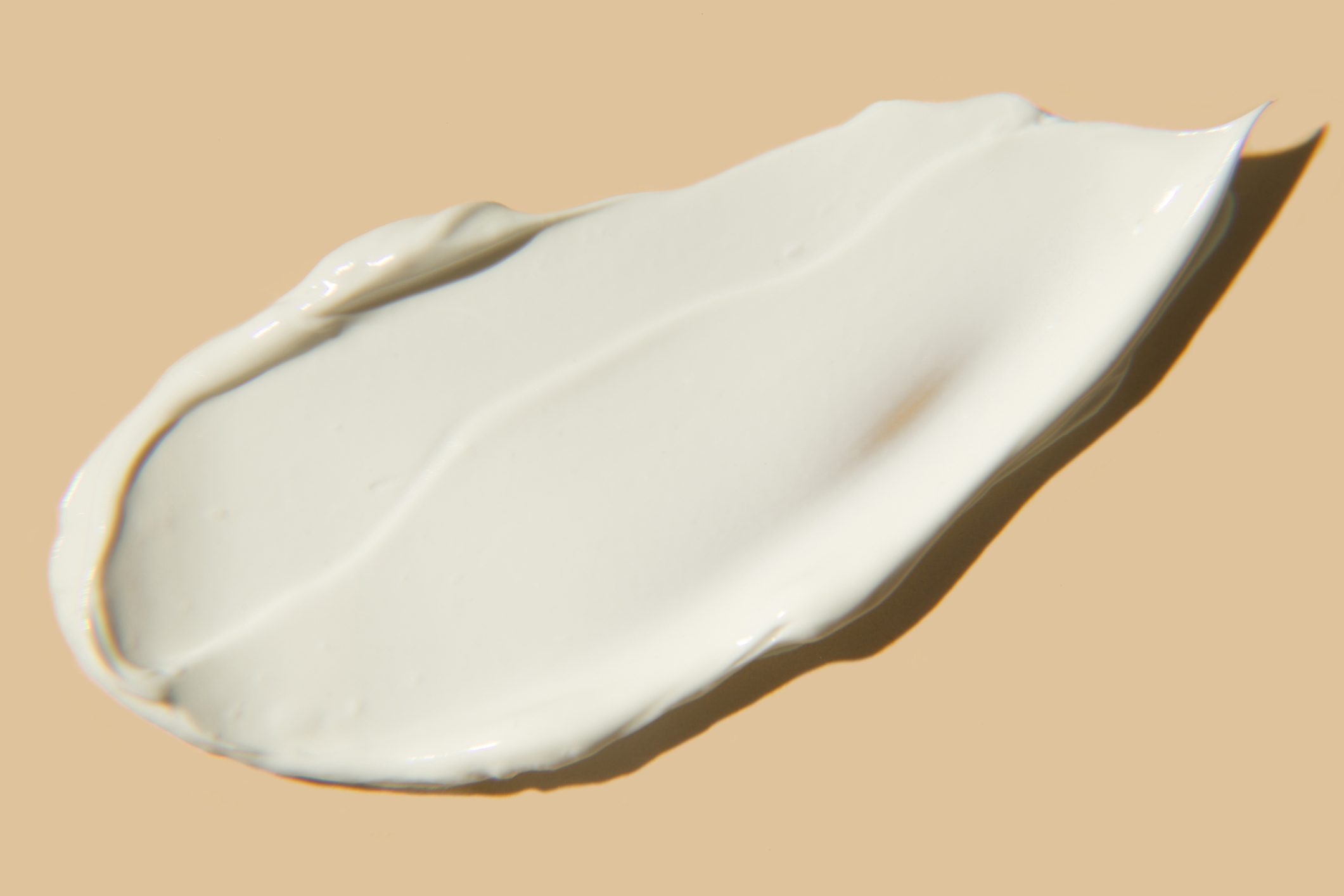 moisturizing lotion smear on a tan background