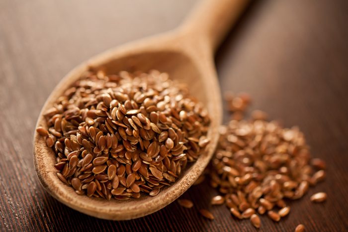 Close-Up Of Brown Flaxseeds On Spoon At Table
