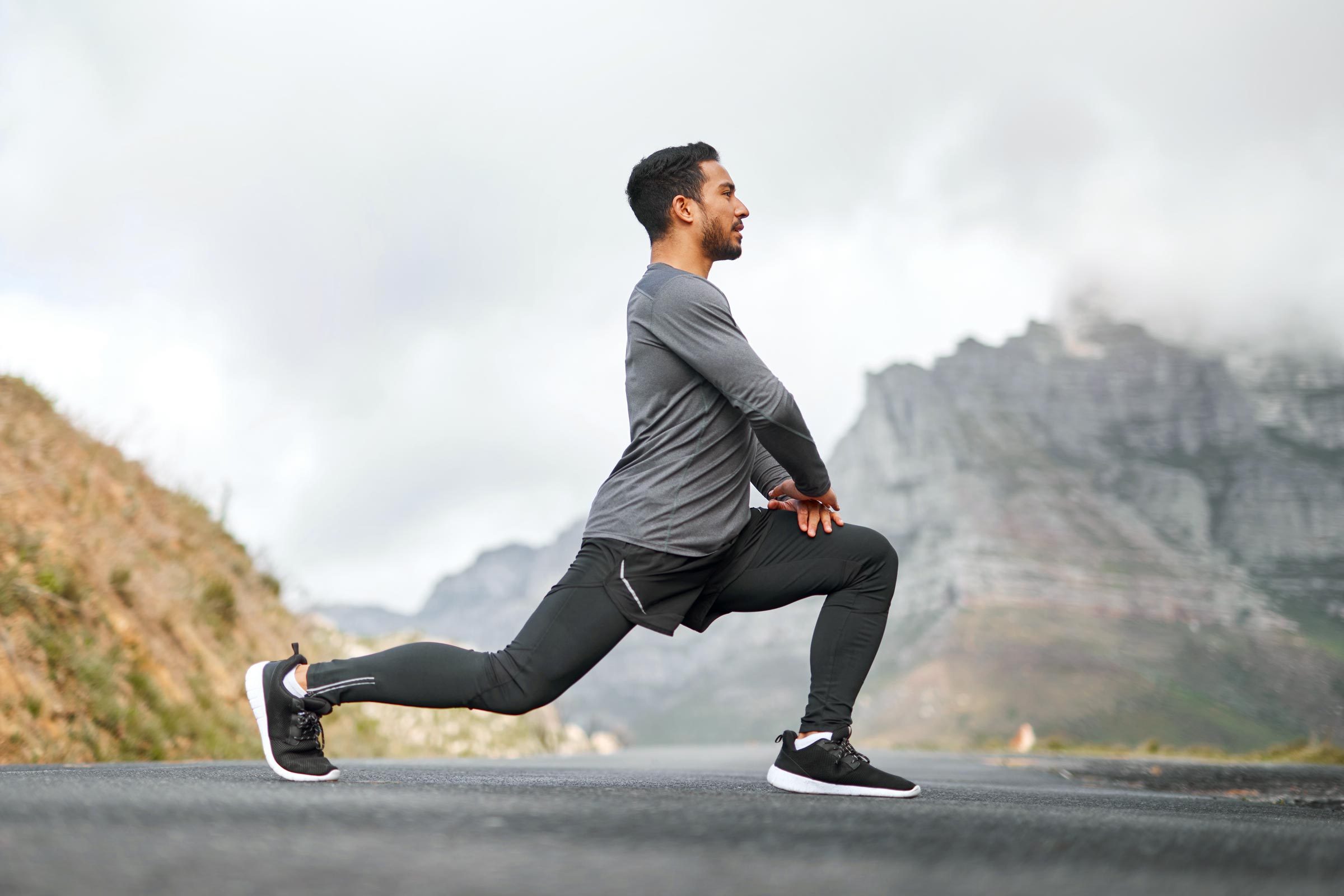 Full length shot of a young man stretching before exercising outdoors alone