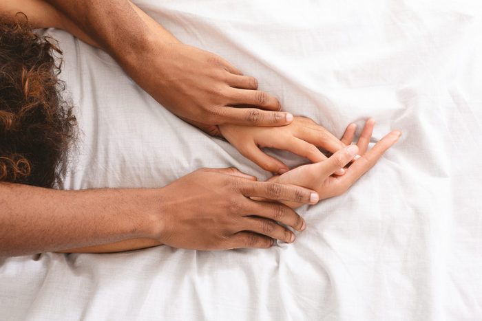 Man and woman hands having sex on bed