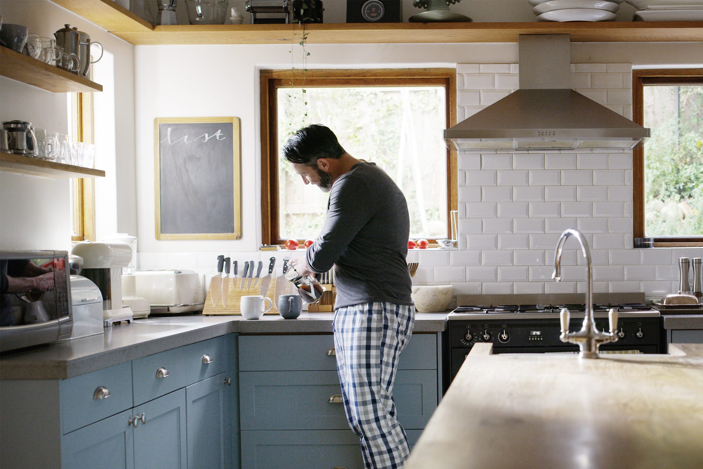 man making two cups of coffee in the kitchen at home