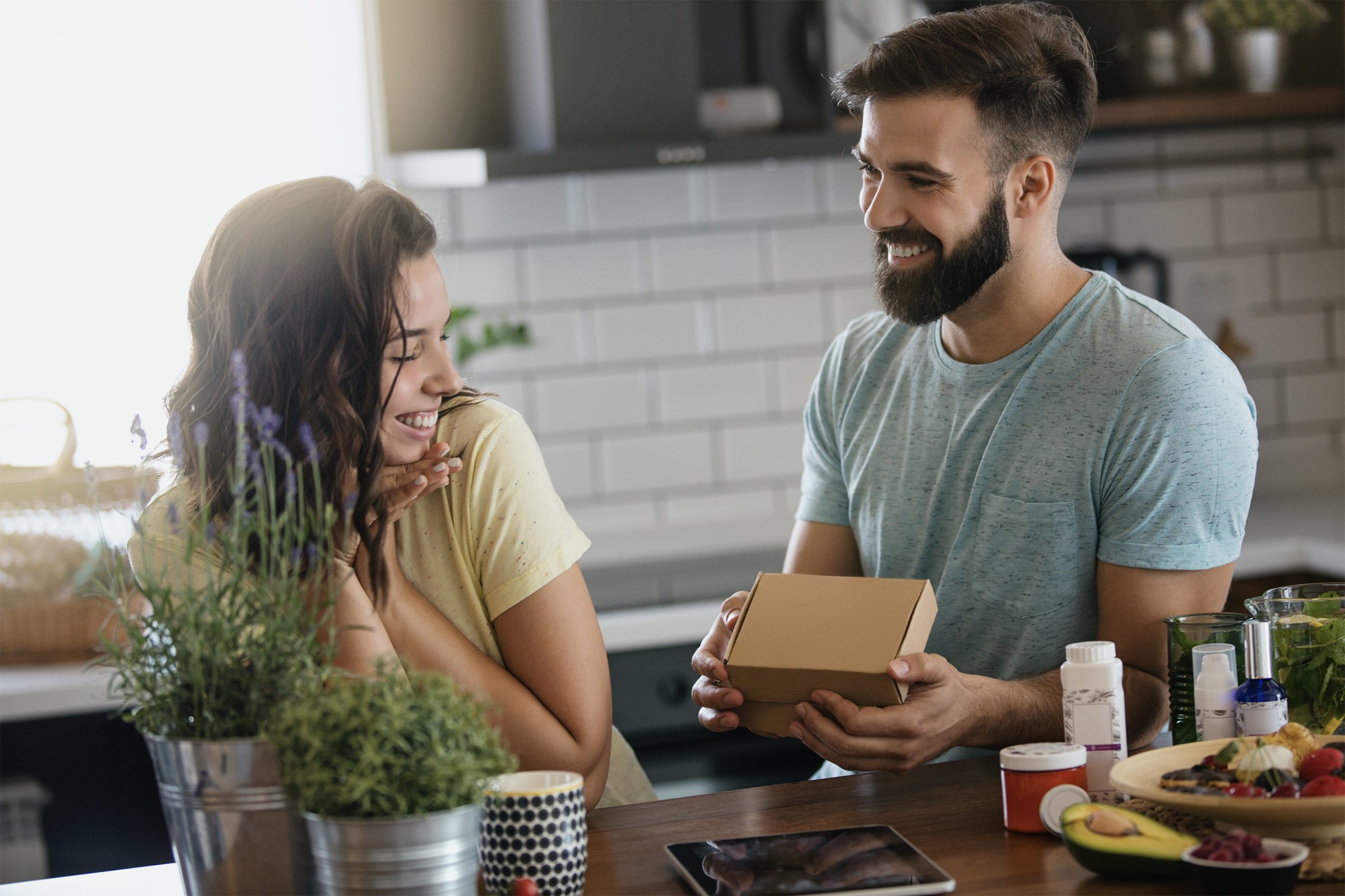 Young couple in the kitchen. The man surprised his girlfriend with an unexpected gift