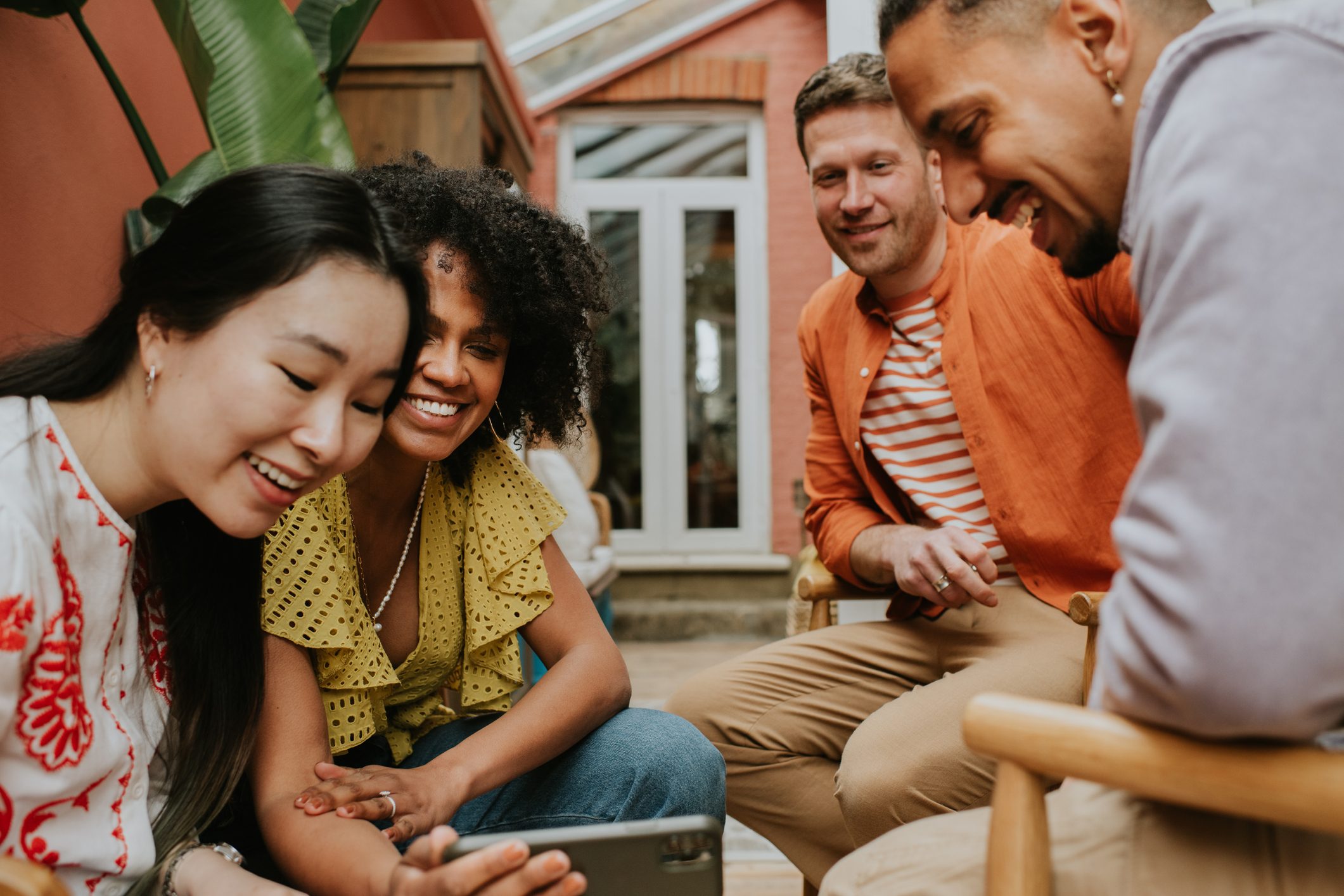 A group of 4 young people watch a video on a smart phone