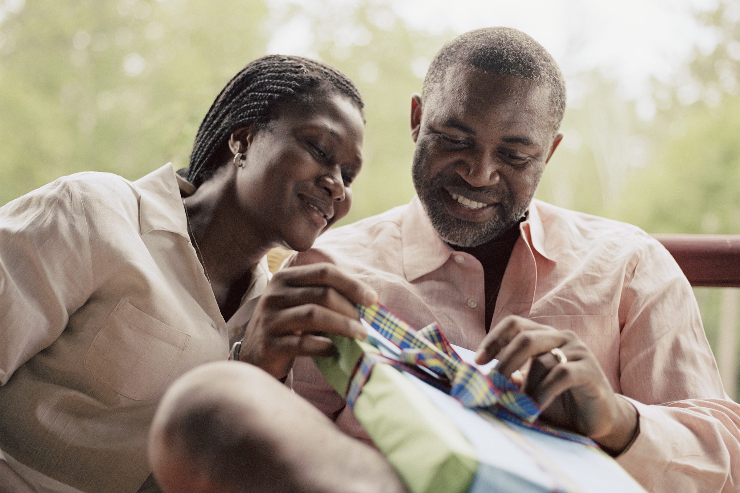 Couple opening gift on porch