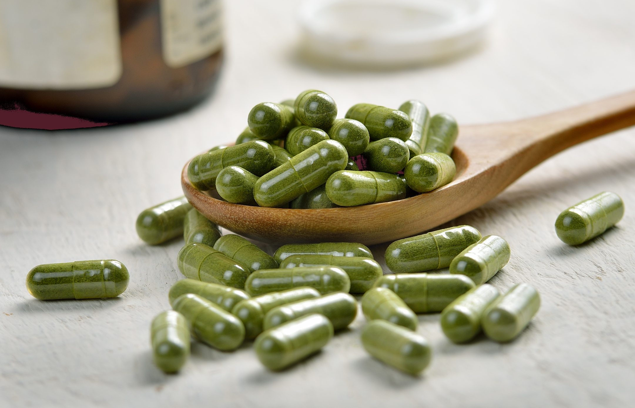 Moringa capsule pills in the woodspoon