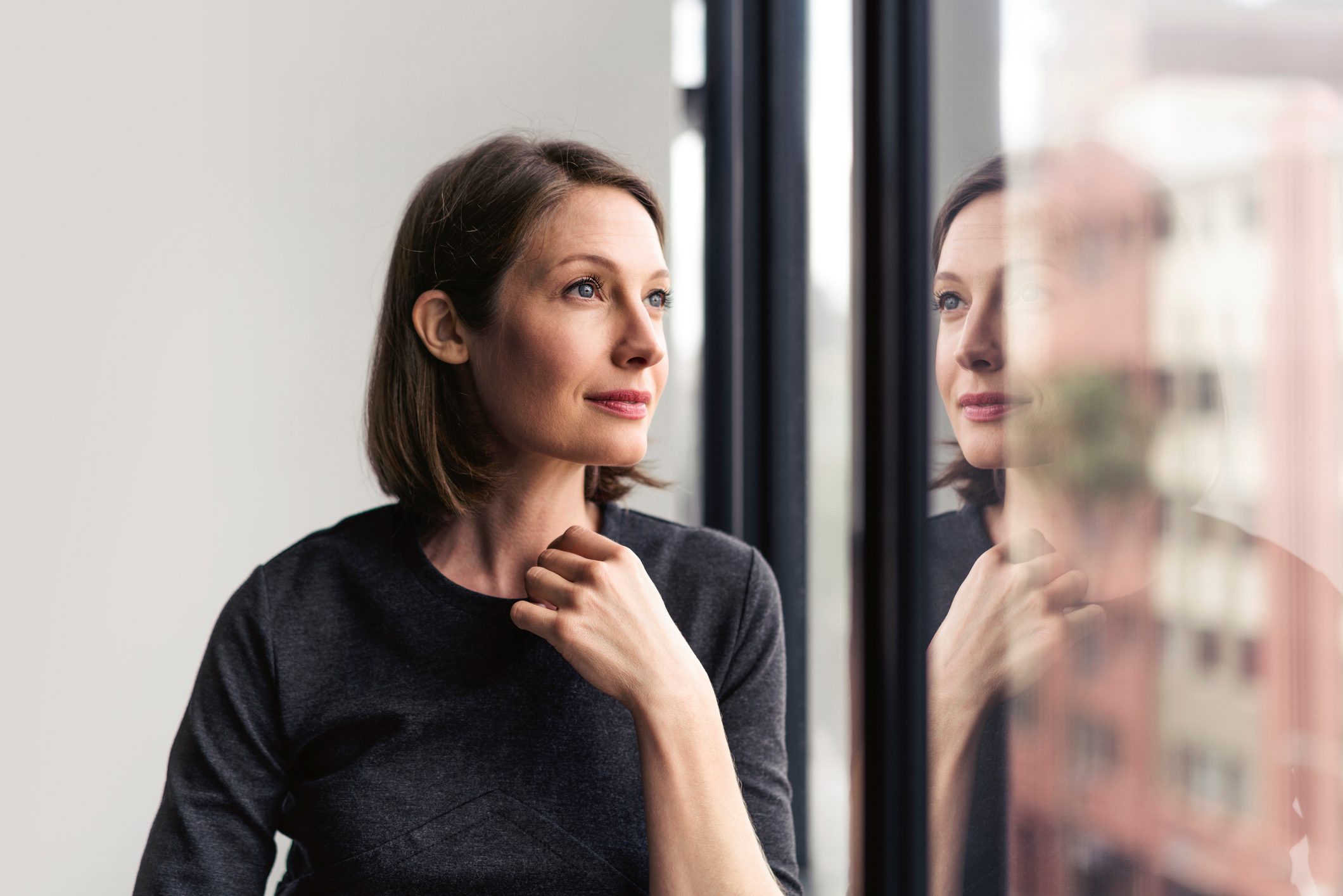 Thoughtful businesswoman looking through window