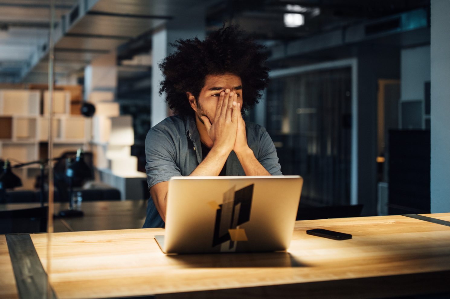 Tired businessman working on laptop at desk