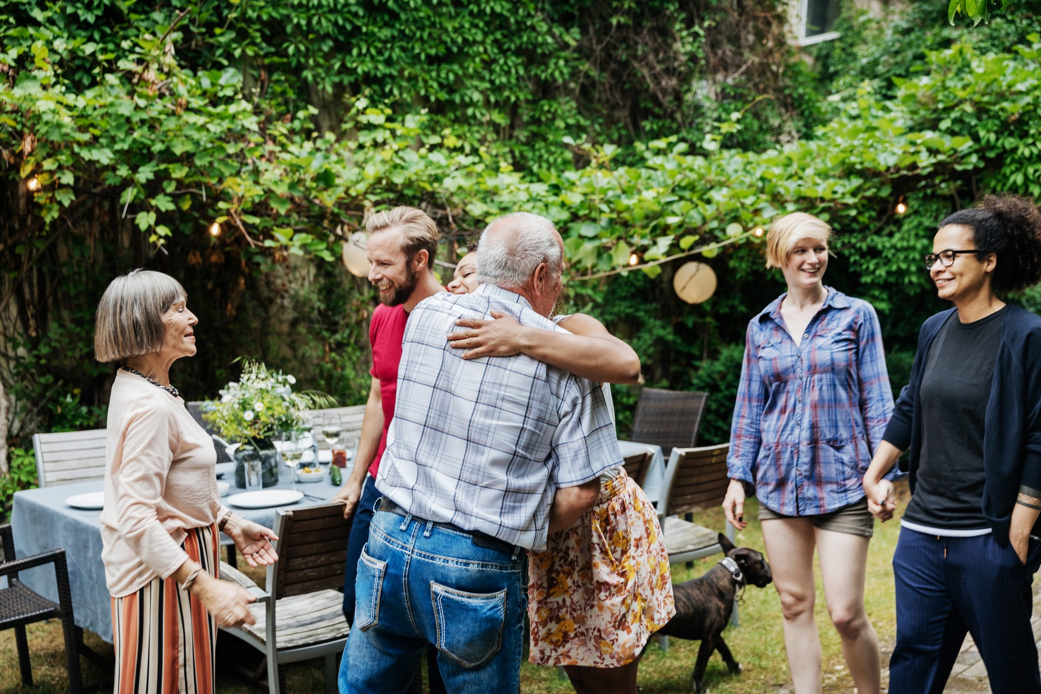 Family Members Embracing Before BBQ Meal Together