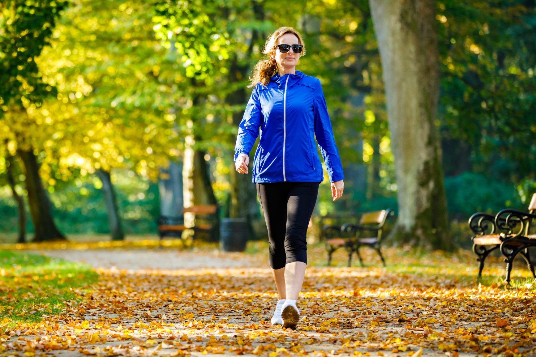 Mid aged woman running in city park