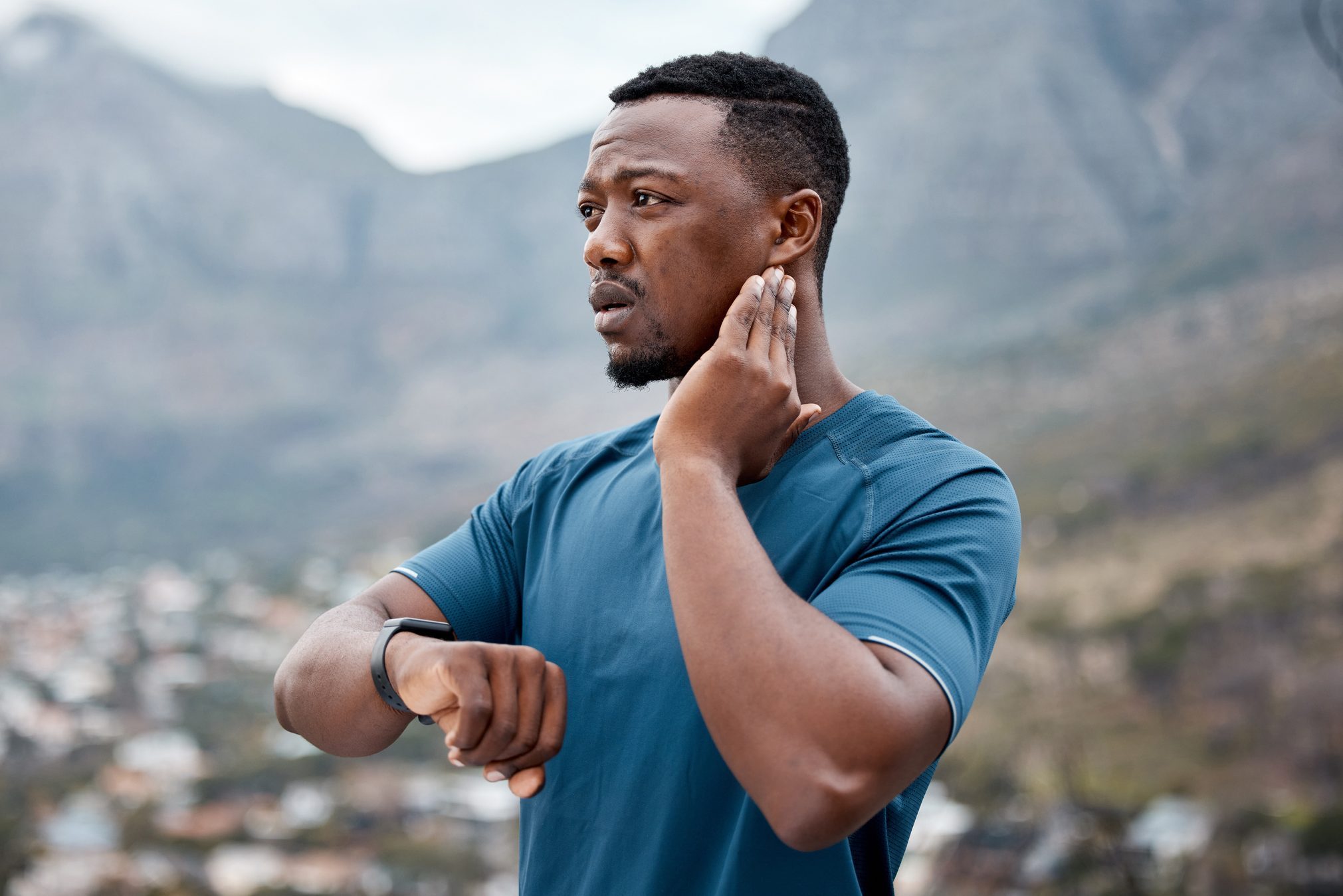 Shot of a sporty young man checking his pulse while exercising outdoors