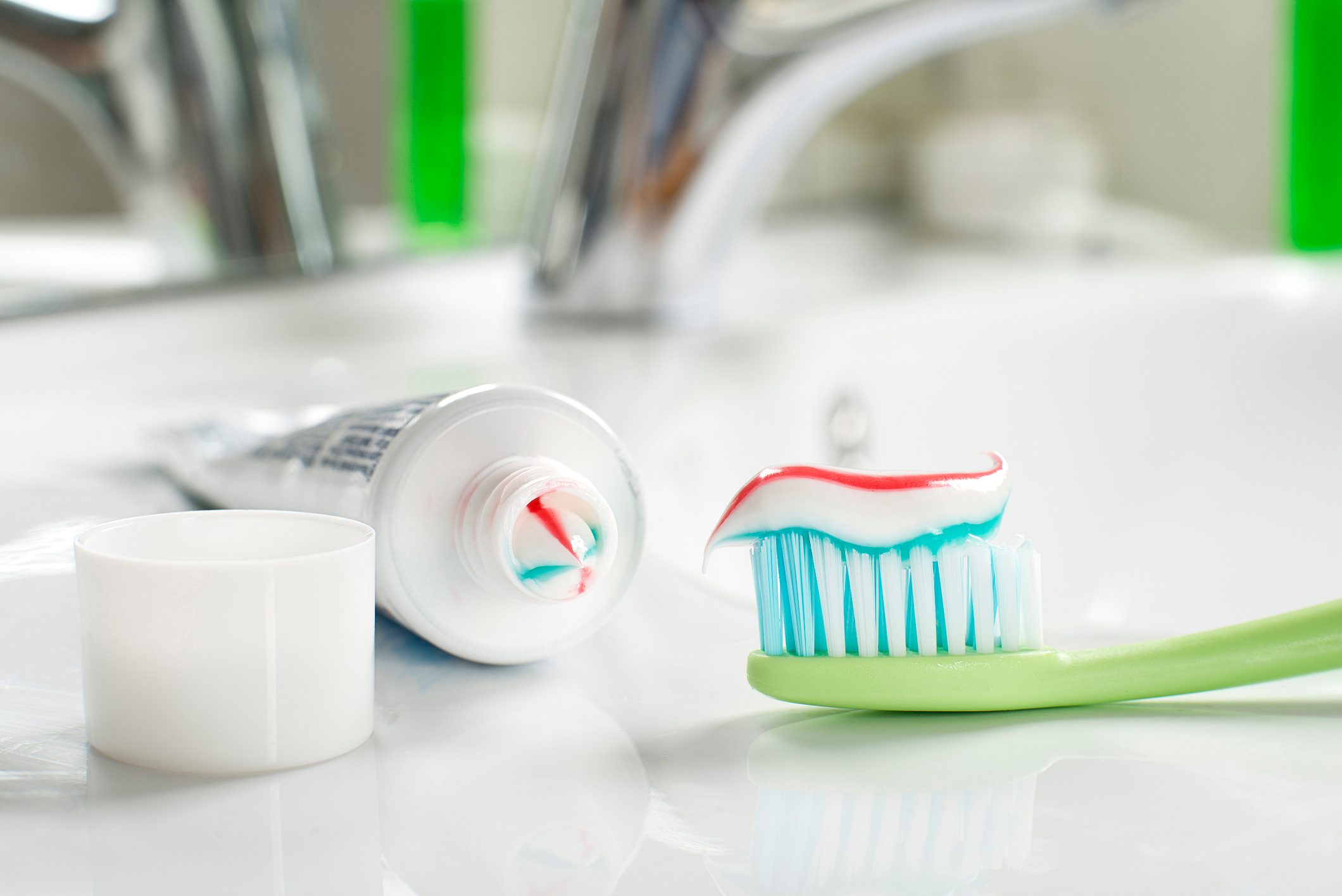 Toothbrush and toothpaste in the bathroom close up.