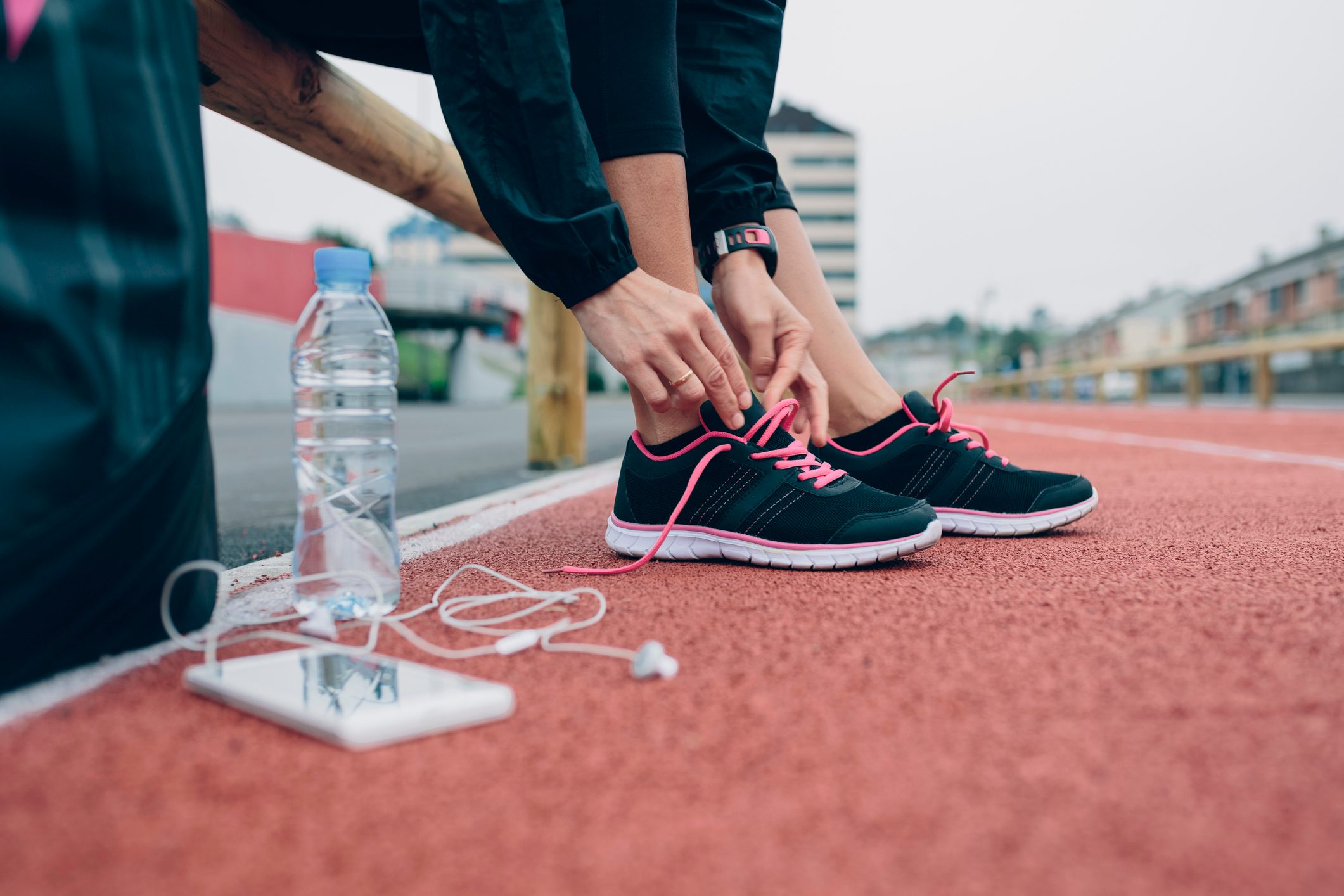 Woman on tartan track tying her shoes