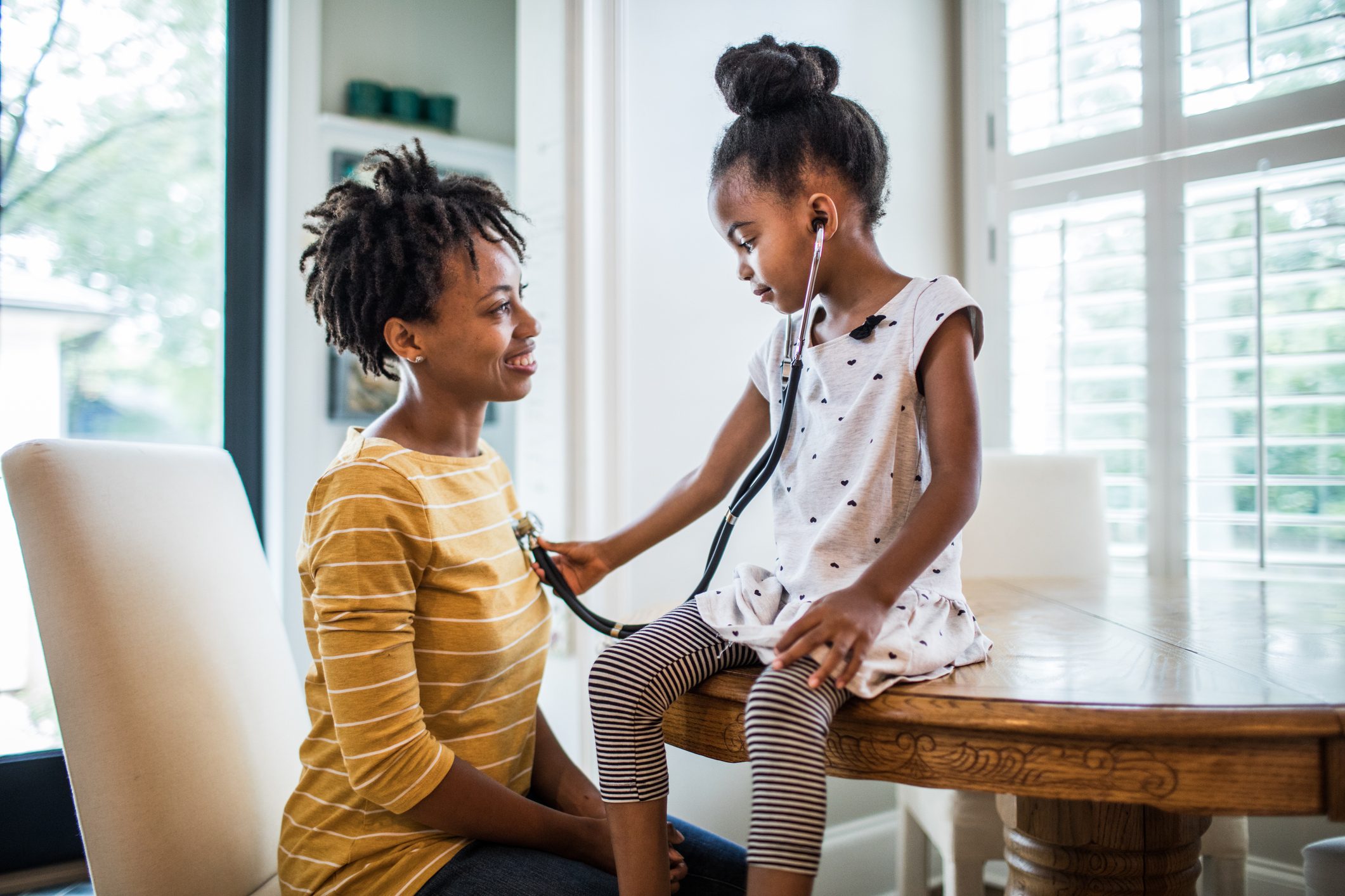 Daughter using stethoscope on mother