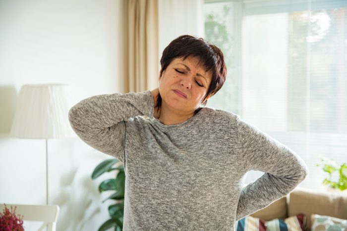 Mature woman suffering from backache at home