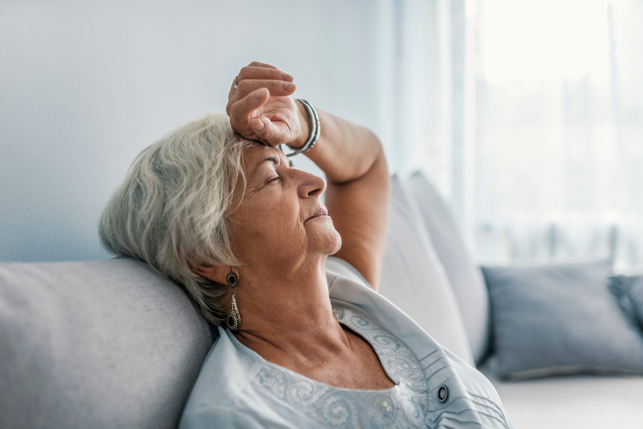 senior woman feeling light headed on the couch