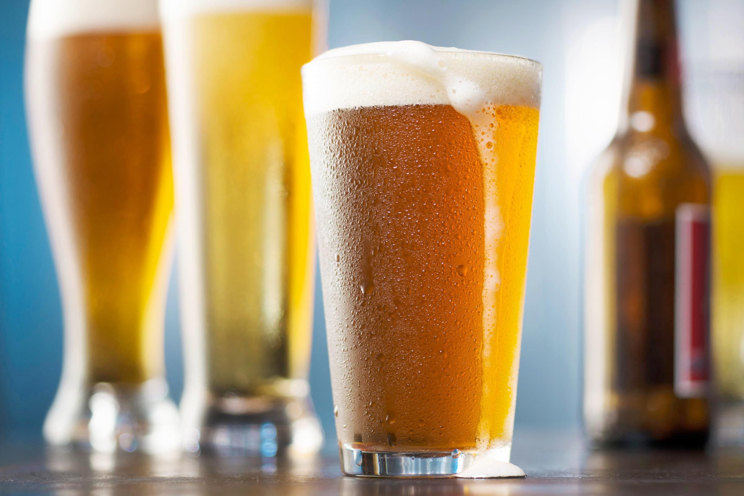 Beer glasses and bottles on a blue background