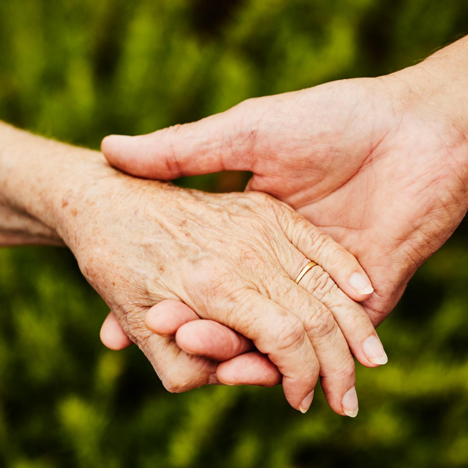 Close up shot of senior couple holding hands