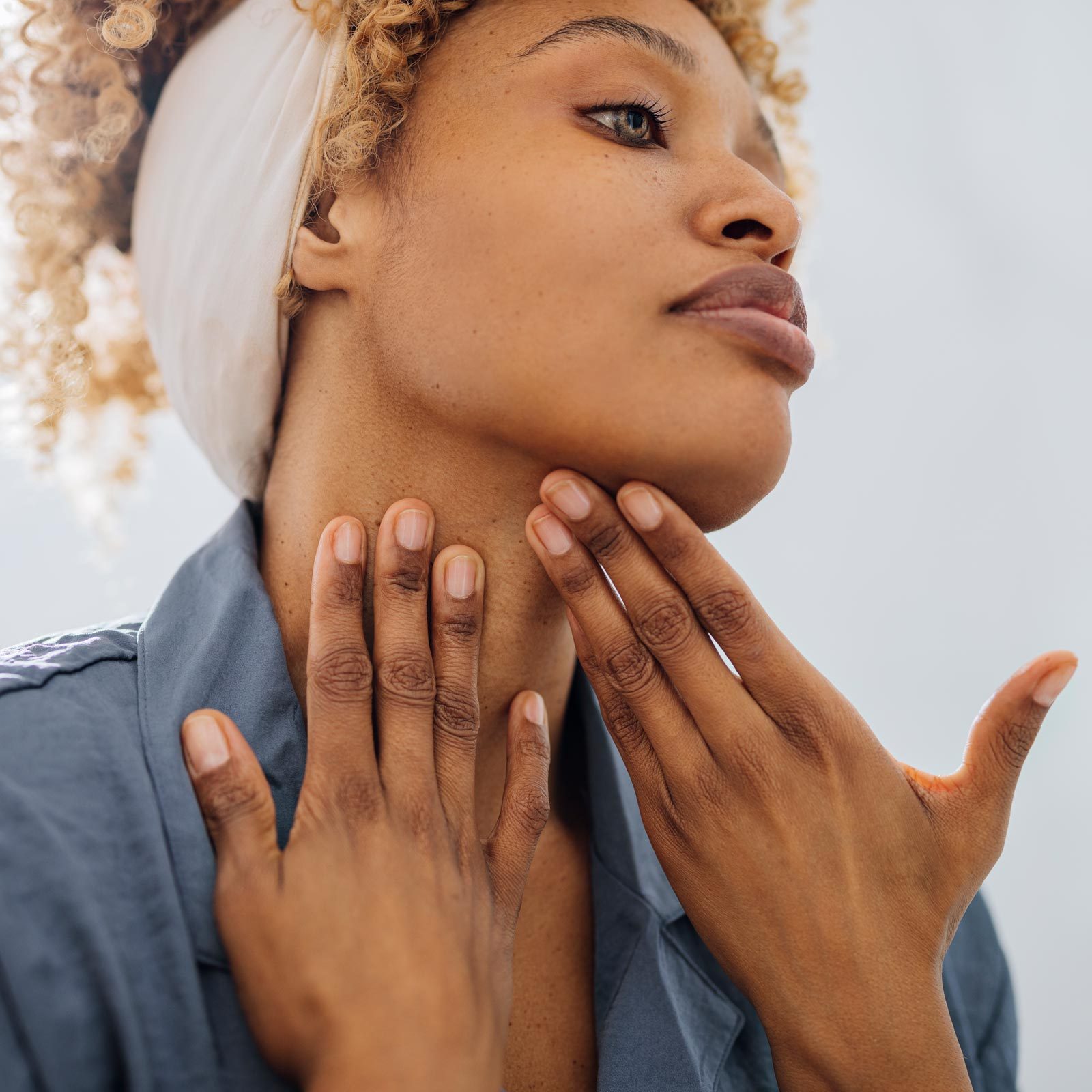 Pretty Woman Applying Face Cream on her Neck