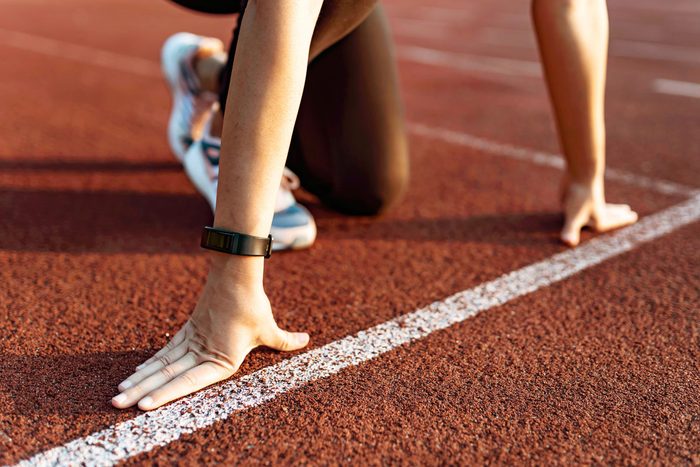 Female athlete on the starting line of a stadium track