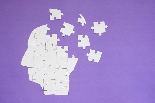 White Jigsaw Puzzle As A Human Brain On Purple Background W Copy Space Creative Idea For Memory Loss Alzheimers Disease Dementia Parkinsons Disease Emotion Stress And Mental Health Concept