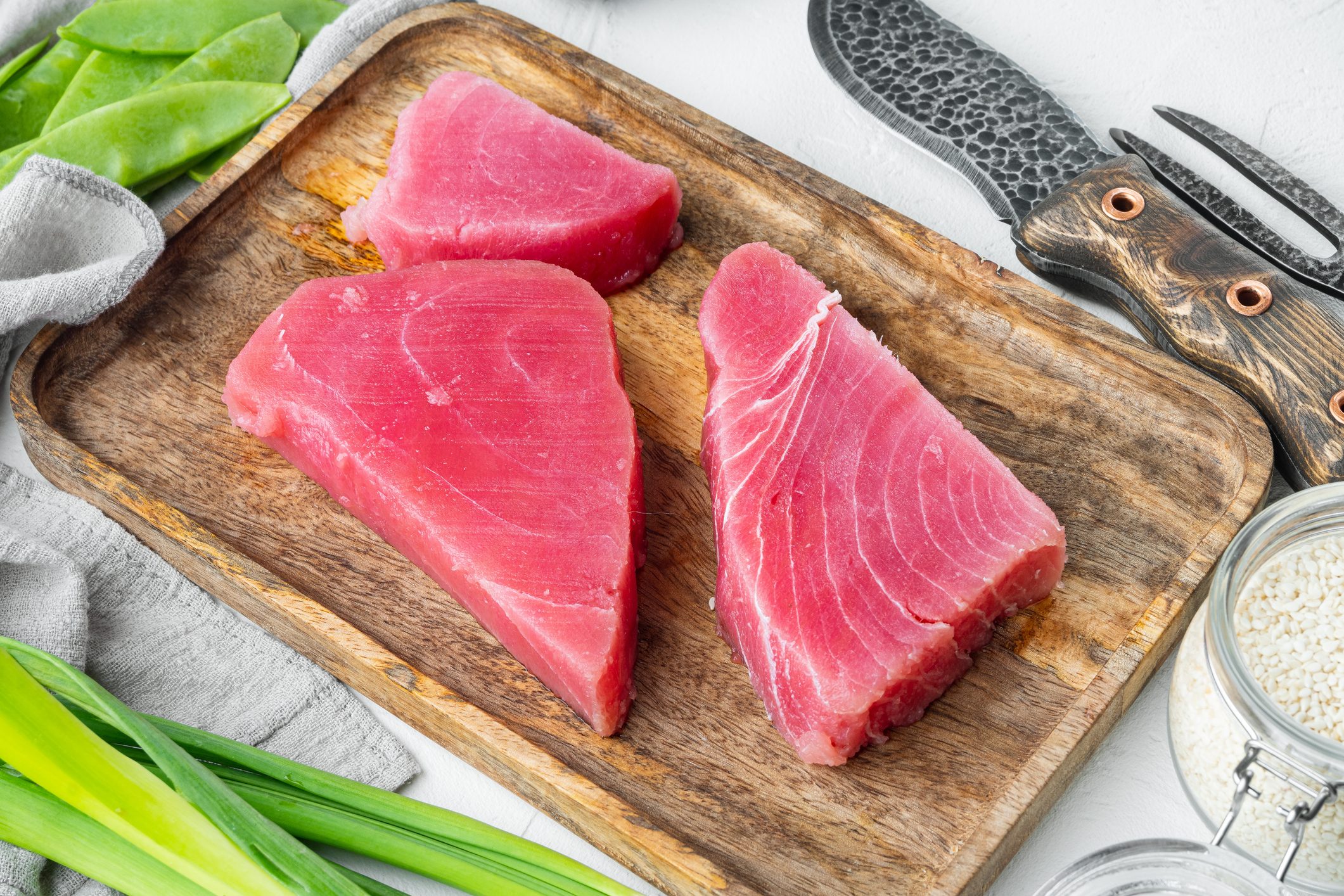 Raw sesame tuna steak ingredients, on wooden tray, on white stone background