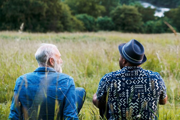 Two men sat, talking, looking at view