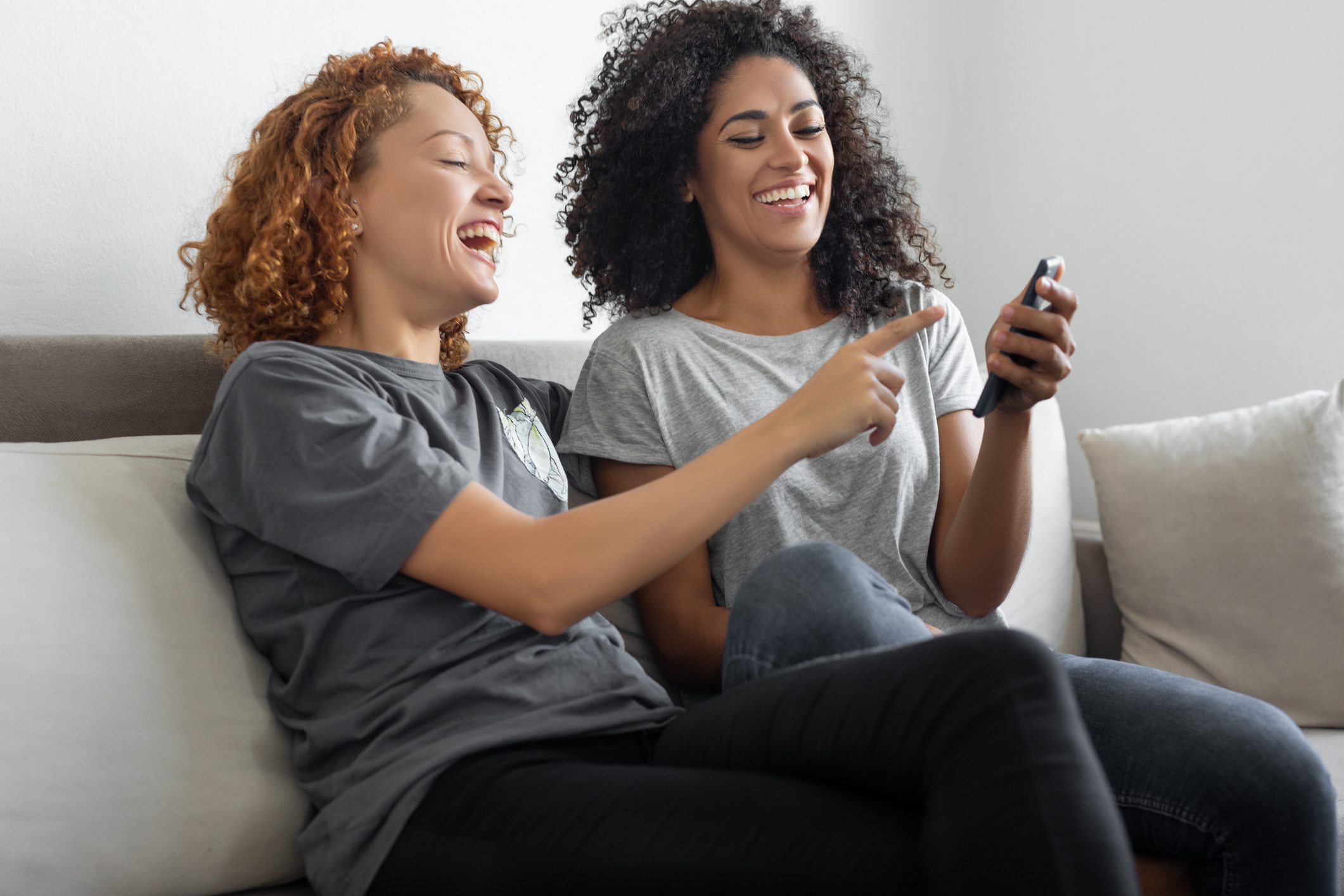 Girls using smartphone sitting on the sofa at home.