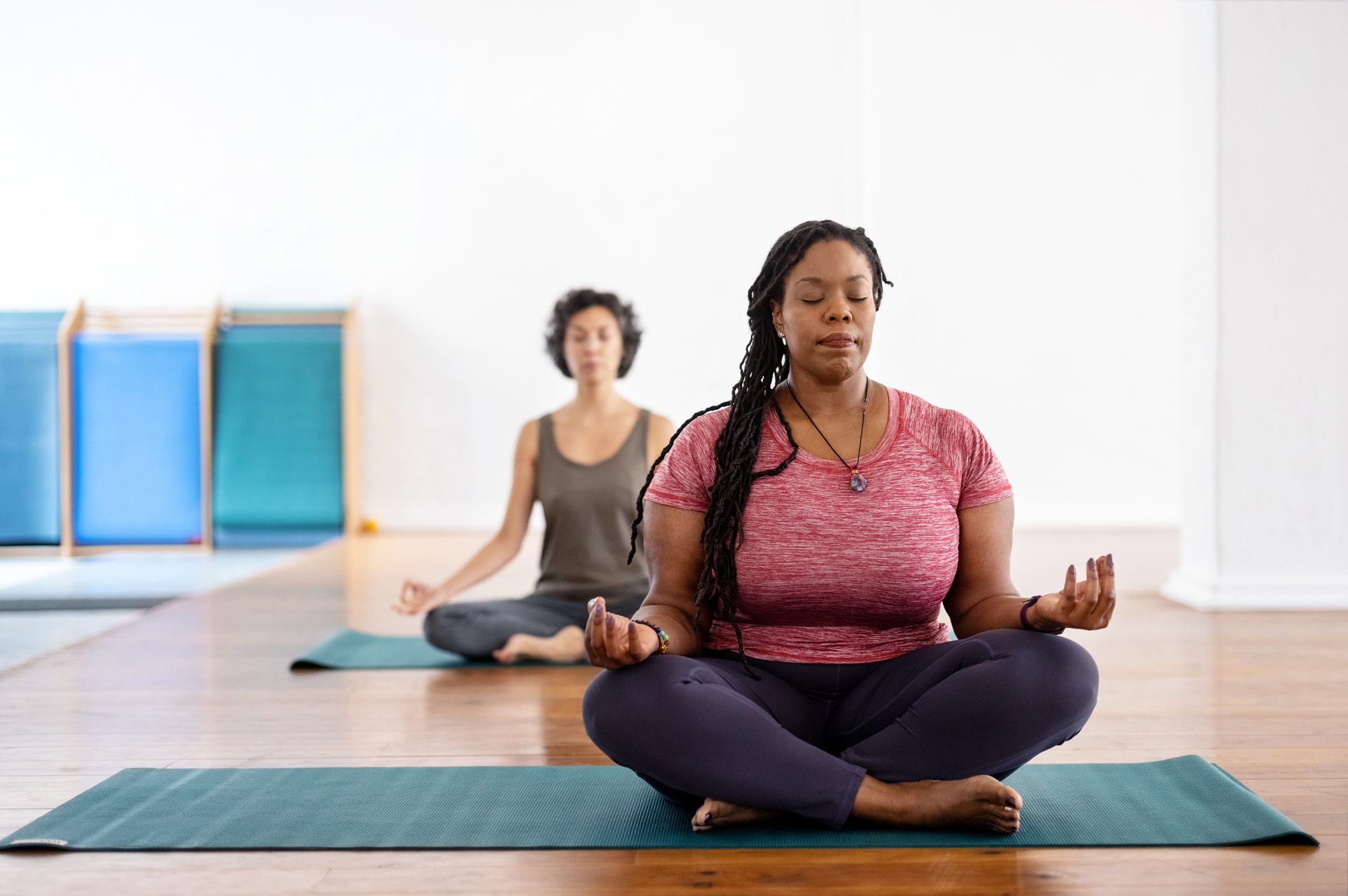 Plus size African woman practicing yoga meditation exercise during yoga class in health club