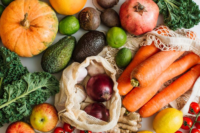 Variety Fresh of organic fruits and vegetables and healthy vegan meal ingredients in reusable eco cotton bags on table. Zero waste shopping concept. Healthy food, clean eating, eco friendly, no plastic. Flat lay, top view
