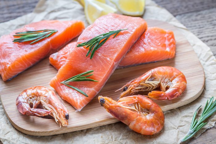 Raw salmon with shrimps on the wooden board