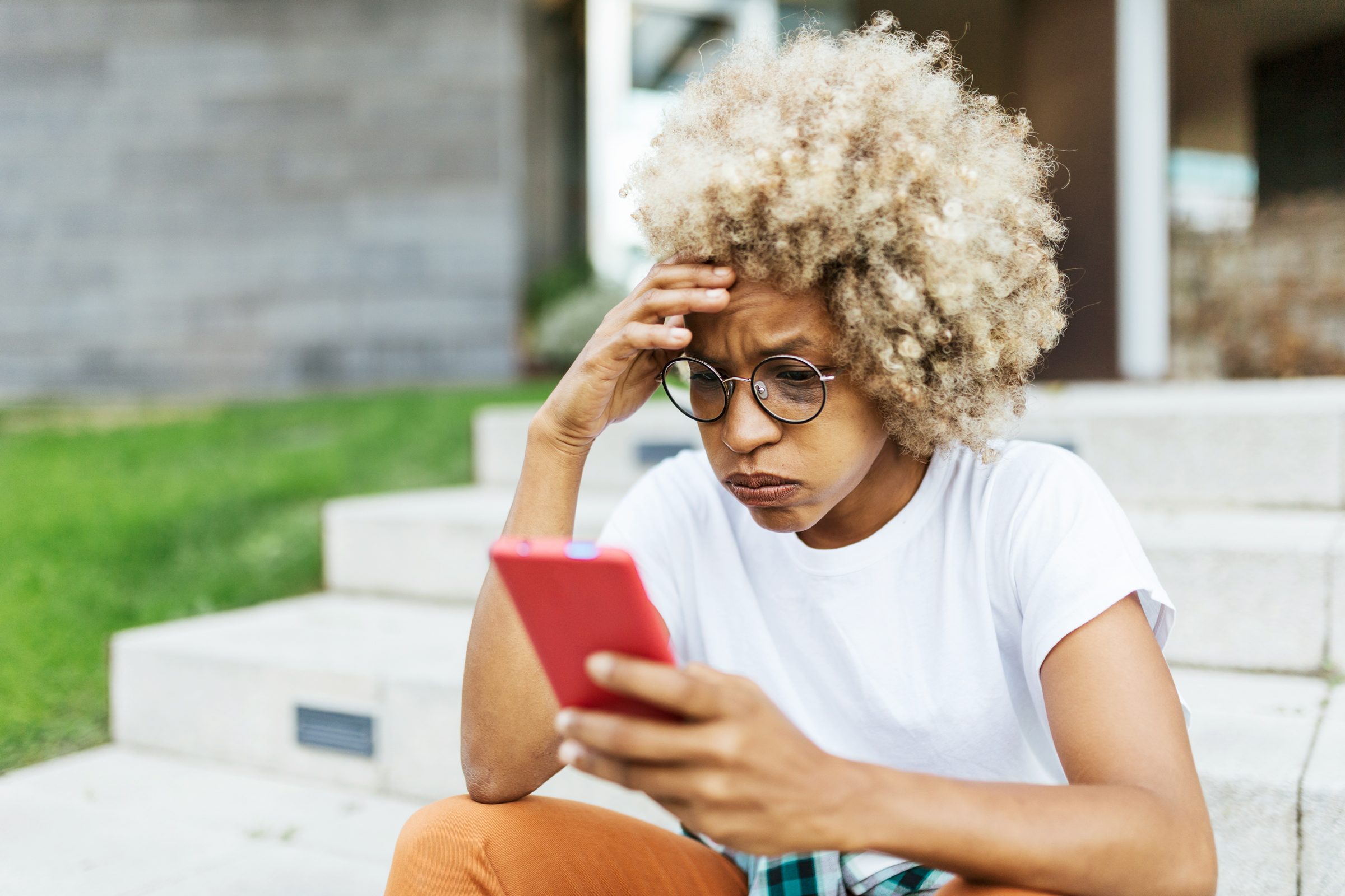 woman looking worried and stress while reading bad news on her mobile phone.