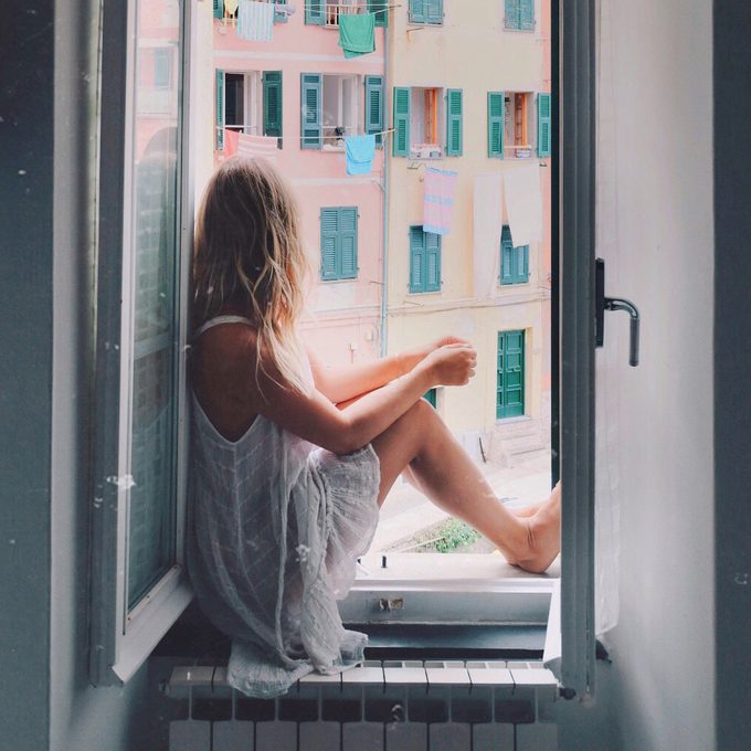 Anna loots sitting in a window sill looking outside
