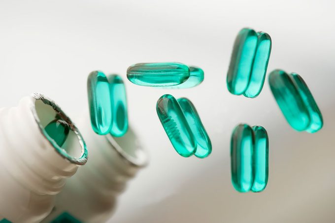 Advil Pills poured On Reflective Surface.