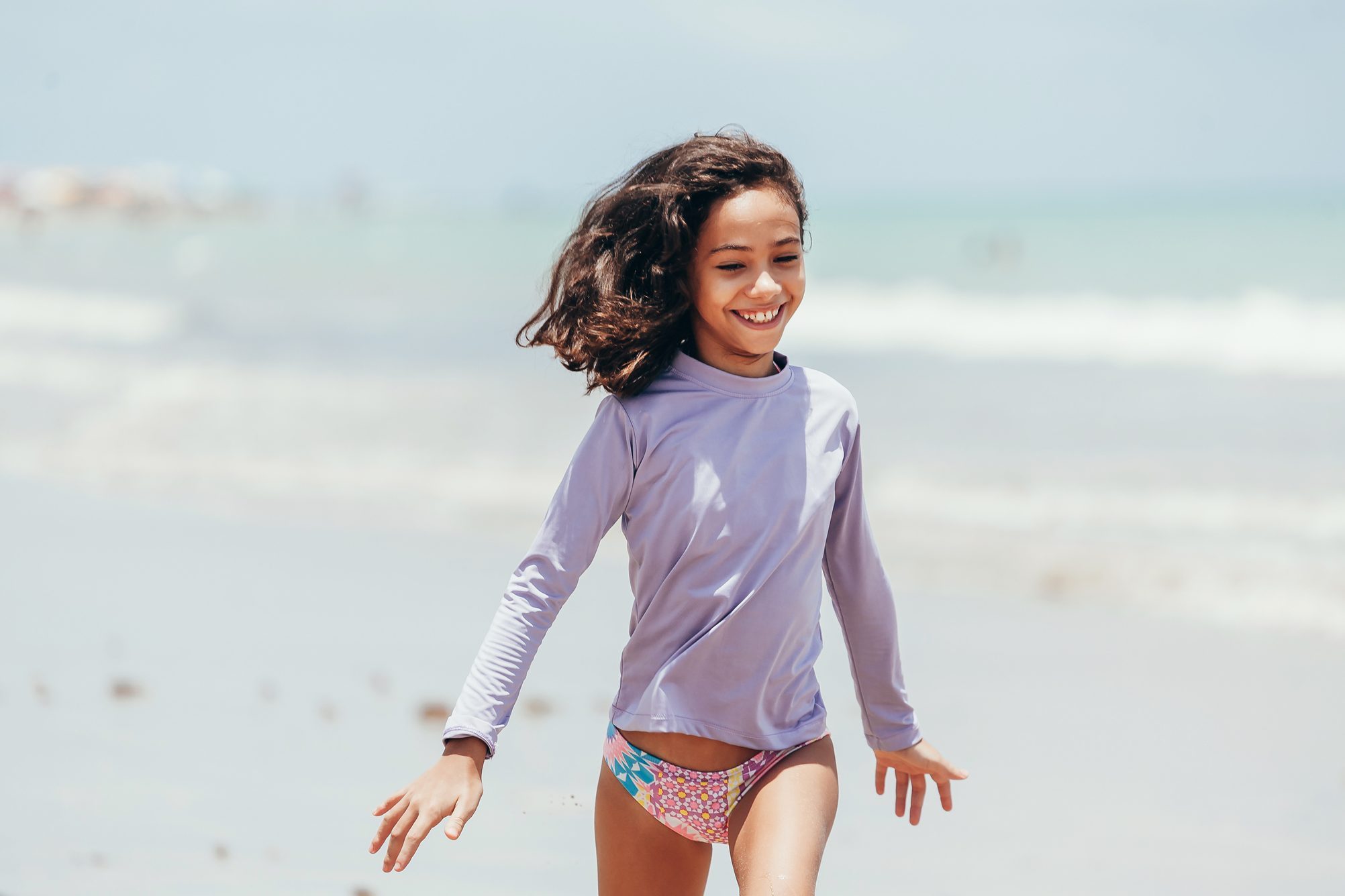 Portrait of little girl wearing sun protective clothing on the beach