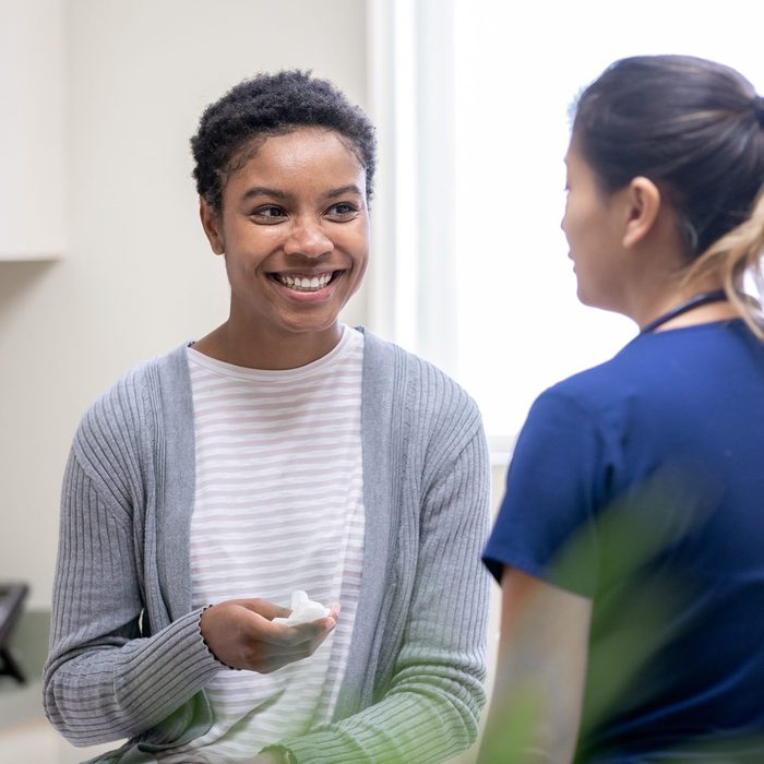 Female patient crying tears of joy after receiving good news from nurse