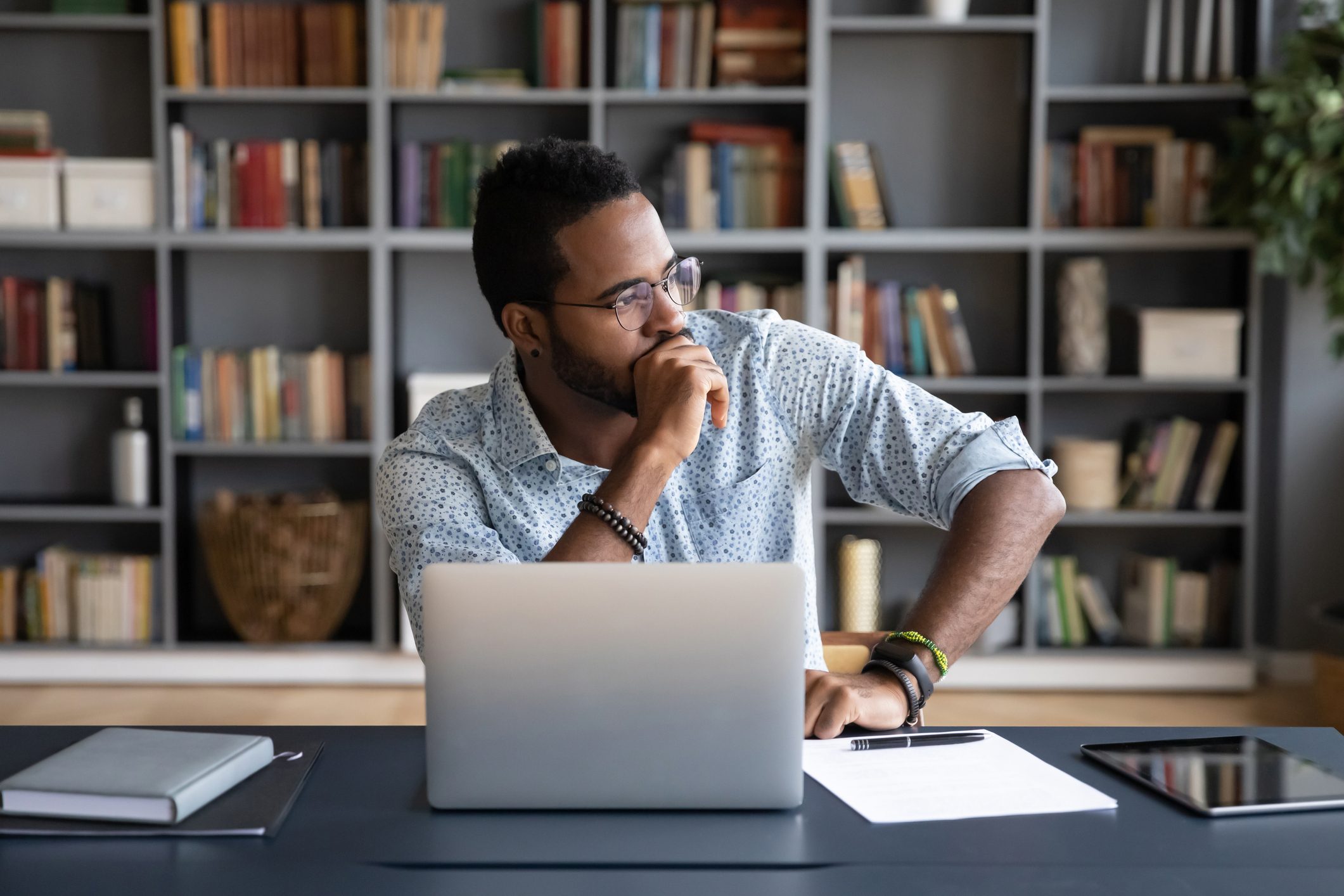 African businessman sitting at workplace thinking over problem solution