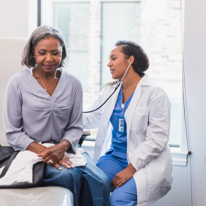 Female doctor listens to patient's lungs