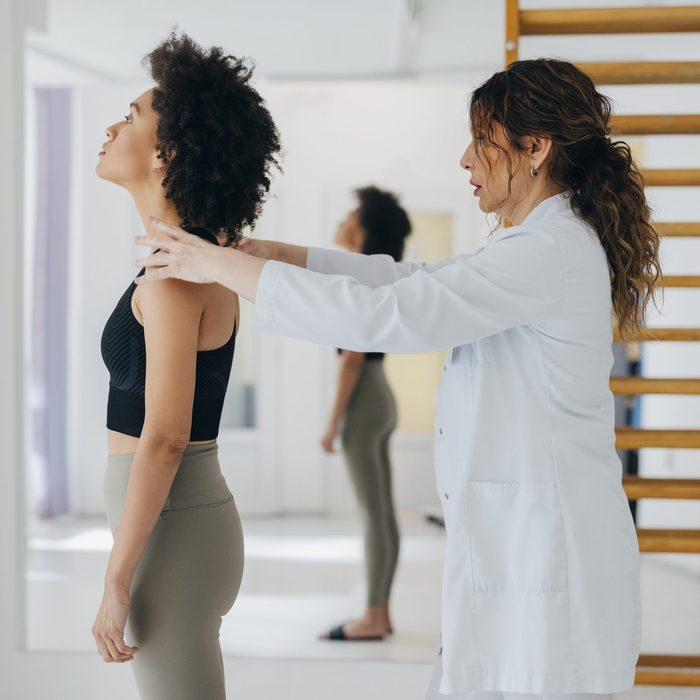 Female Physical Therapist is Checking the Neck and Shoulders of a Young Woman
