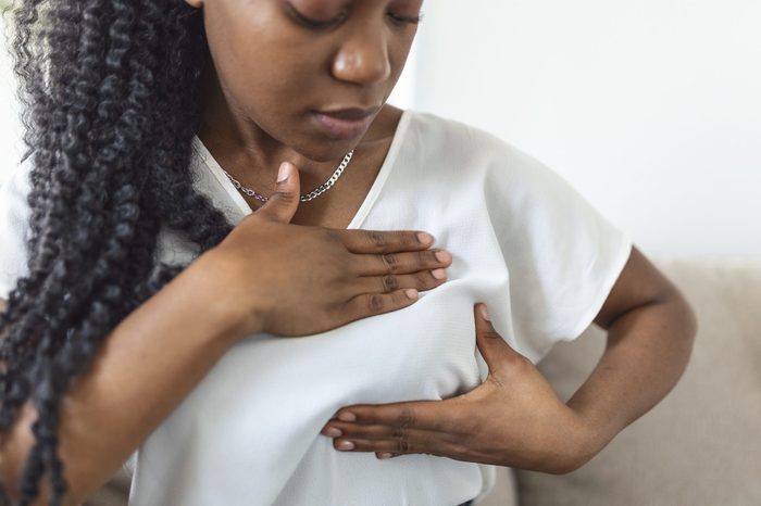 Young African American woman doing a breast exam on herself