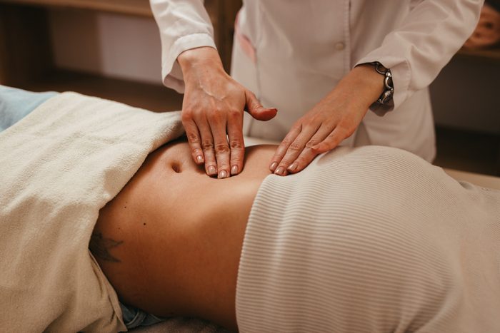 doctor checking woman's abdomen at OBGYN