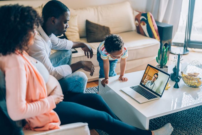 Pregnant woman at home talking on video call with her doctor