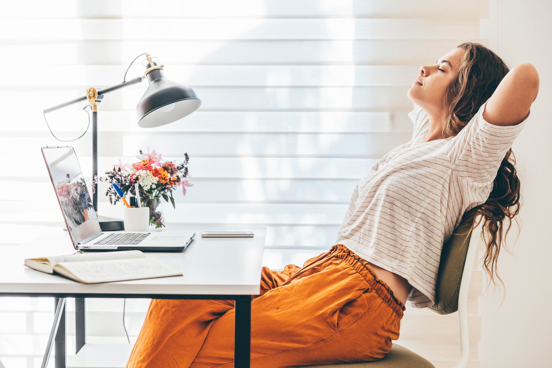 Woman having break while working from home using laptop.