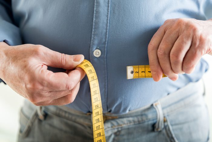 man measuring his waist