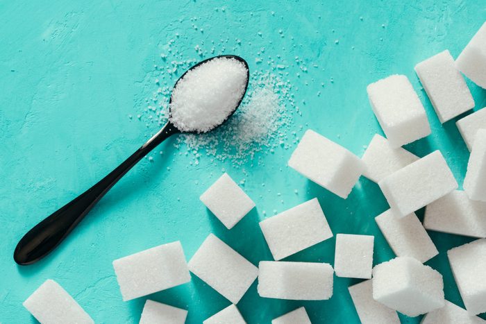 Top view of white sugar cubes on turquoise background