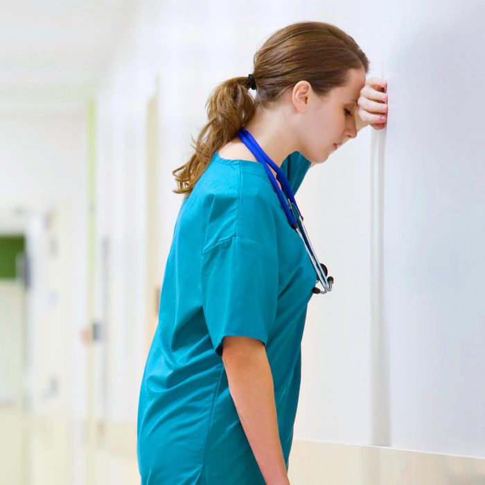 annoyed doctor resting her head on a wall