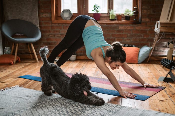 Woman doing yoga with her dog