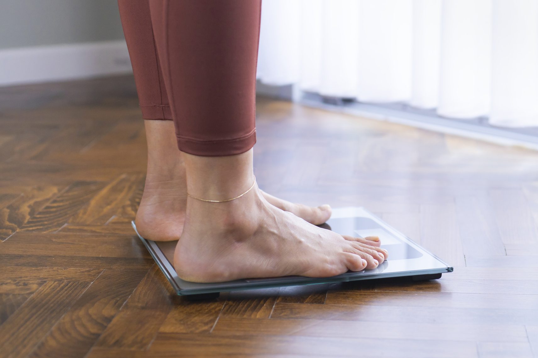 Young woman on home scales